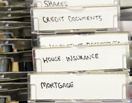 Detail of a filing cabinet with tabs labelled for mortgage documents, house insurance, etc.