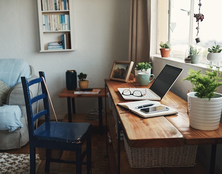 Cropped shot of technology and a notebook on a desk in an empty home office during the day